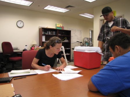 Two men and one woman working on paperwork